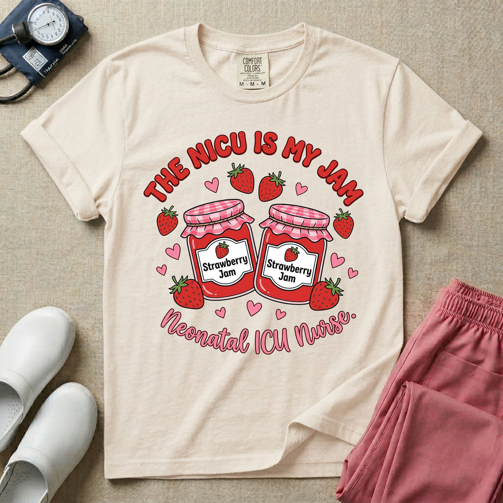A t-shirt featuring two jars of strawberry jam surrounded by small hearts and strawberries with the text THE NICU IS MY JAM arched above and Neonatal ICU Nurse written in a retro script below.