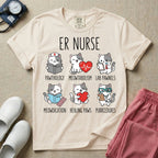 A funny t-shirt for emergency room nurses featuring the text "ER NURSE" above a grid of six cute cartoon cats demonstrating medical puns, including a cat reading for "PAWTHOLOGY", a cat with an ECG heart for "MEOWTABOLISM", a cat holding a test tube for "LAB PAWNELS", a cat with pills for "MEOWDICATION", a cat holding a heart for "HEALING PAWS", and a cat with a stethoscope for "PURRCEDURES".