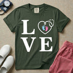 A minimalist nursing t-shirt featuring the word LOVE stacked in large white serif letters, with the letter O replaced by a white stethoscope shaped like a heart containing two small baby footprints, one pink and one blue.
