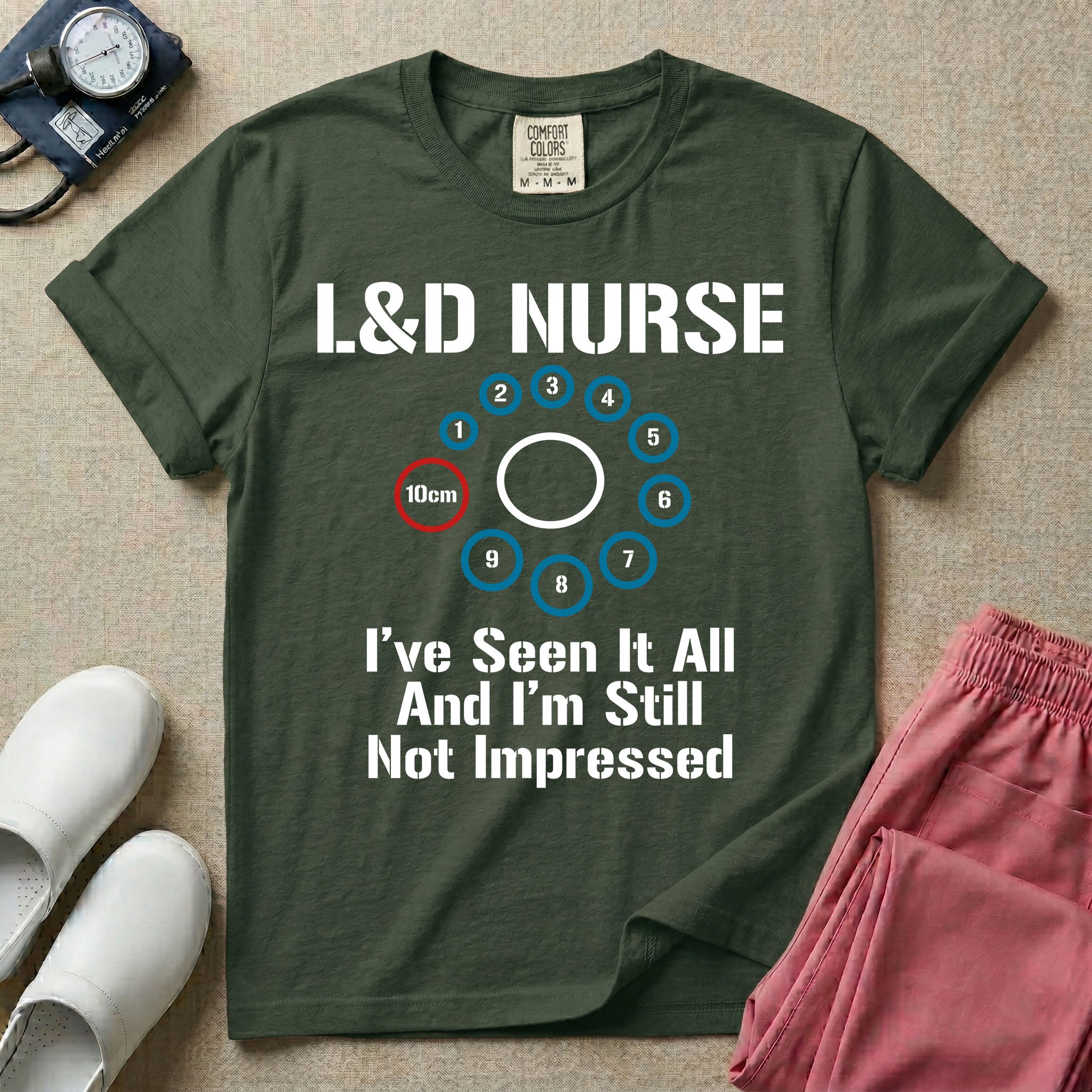 A humorous Labor and Delivery nurse t-shirt featuring a cervical dilation chart graphic highlighting 10cm, with the text "L&D NURSE" at the top and "I've Seen It All And I'm Still Not Impressed" at the bottom.
