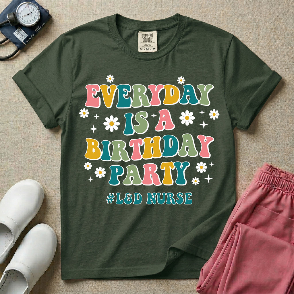 A retro graphic tee for labor and delivery nurses featuring bubble lettering that reads "EVERYDAY IS A BIRTHDAY PARTY #L&D NURSE" surrounded by small daisies and stars.