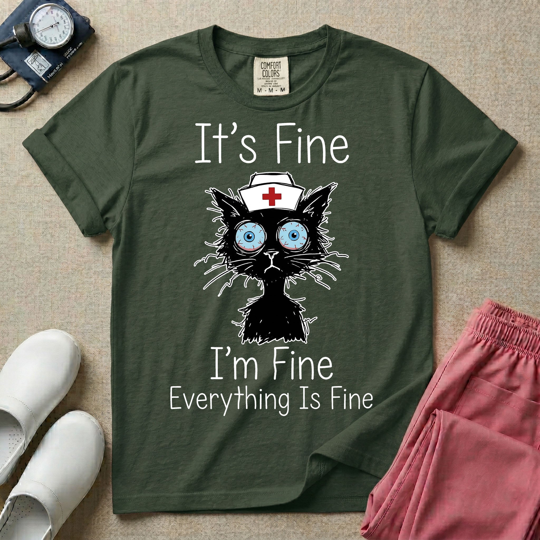 General nursing t-shirt featuring a humorous graphic of a frazzled black cat wearing a medical cross nurse cap alongside the text "It's Fine I'm Fine Everything Is Fine".