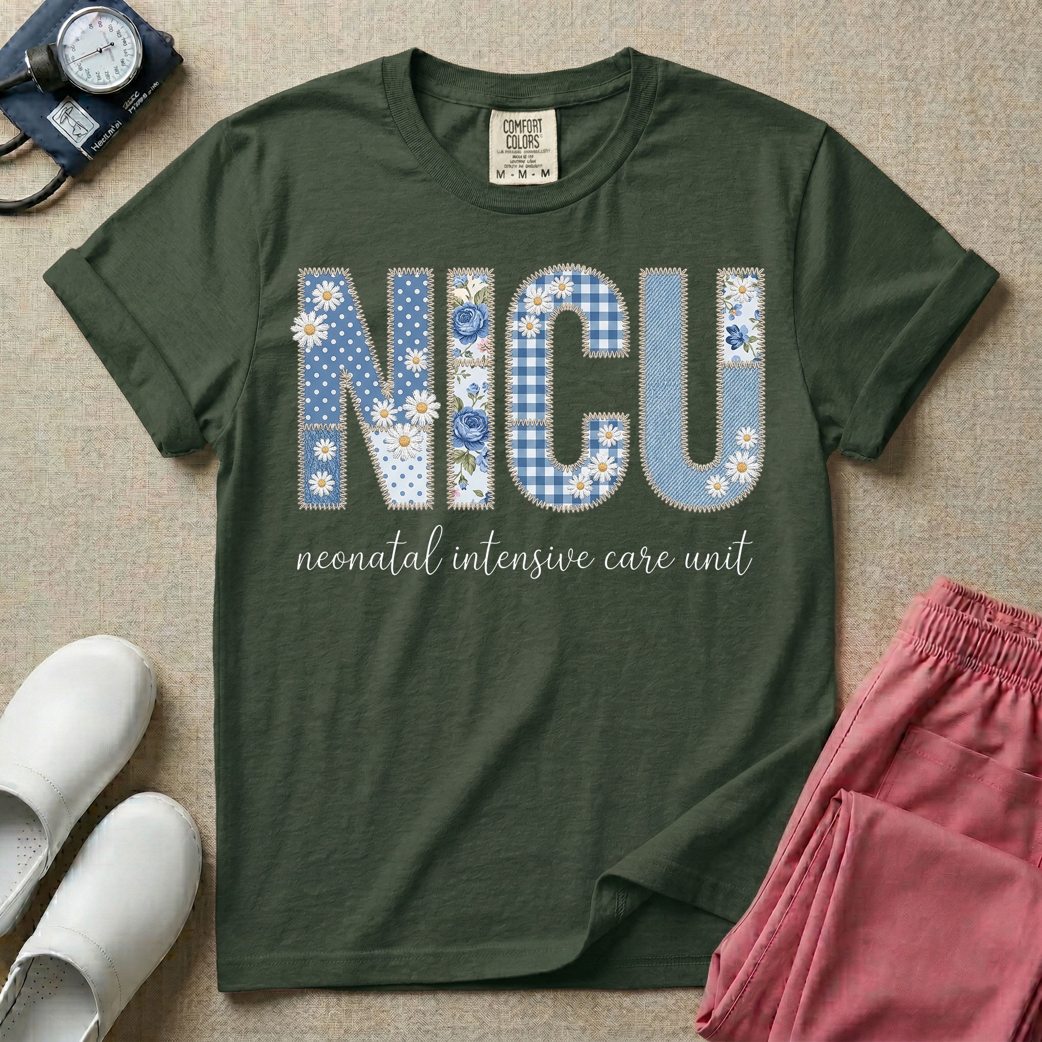 Neonatal Intensive Care Unit NICU nursing t-shirt featuring a faux-embroidery graphic of the letters NICU filled with blue floral and checkered patterns, positioned above the cursive text "neonatal intensive care unit".