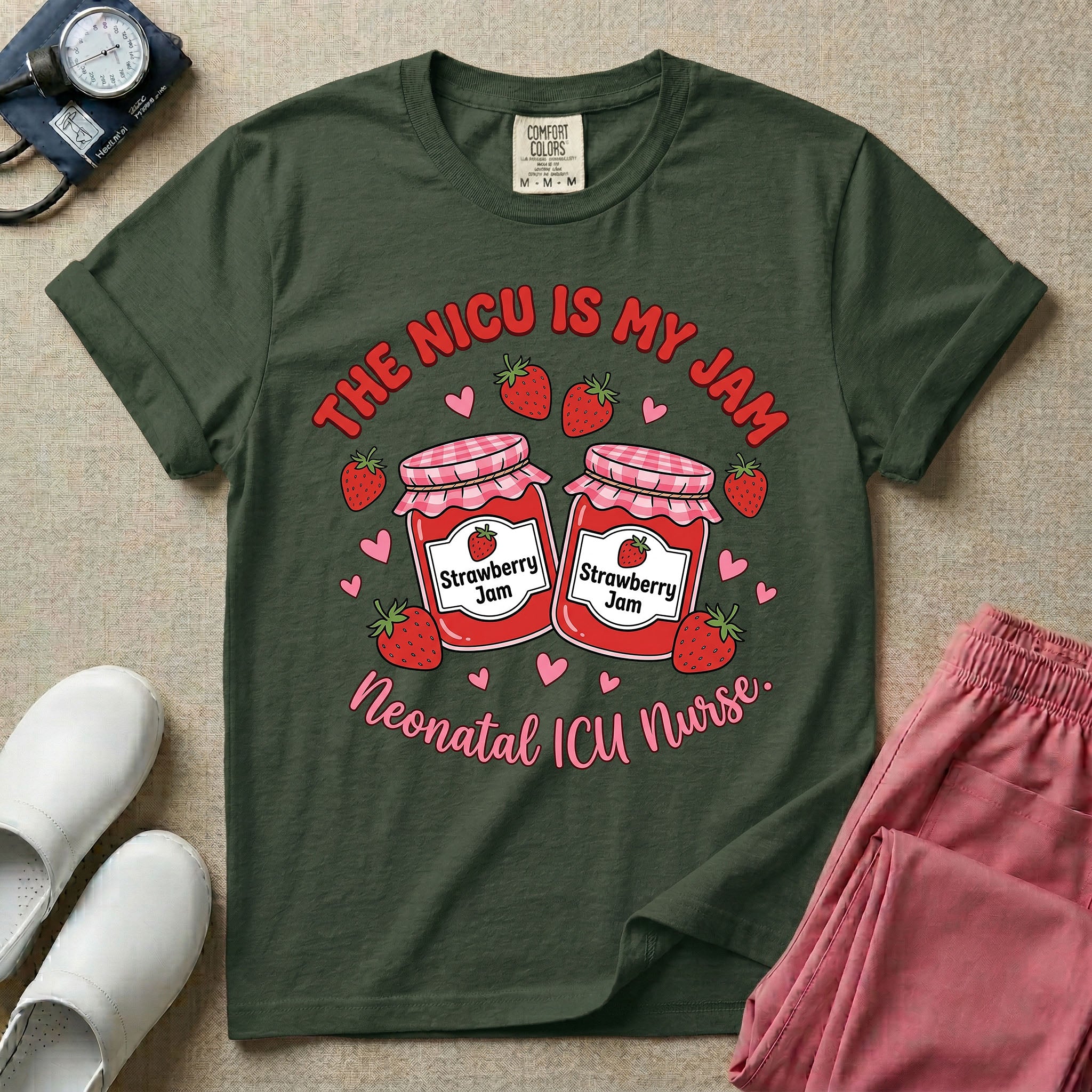A t-shirt featuring two jars of strawberry jam surrounded by small hearts and strawberries with the text THE NICU IS MY JAM arched above and Neonatal ICU Nurse written in a retro script below.