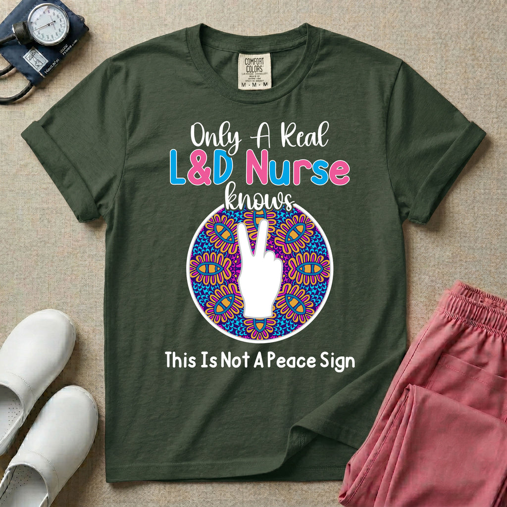 A humorous Labor and Delivery nurse graphic featuring a hand holding up two fingers inside a colorful boho mandala pattern, surrounded by text that reads Only A Real L&D Nurse Knows above and This Is Not A Peace Sign below.