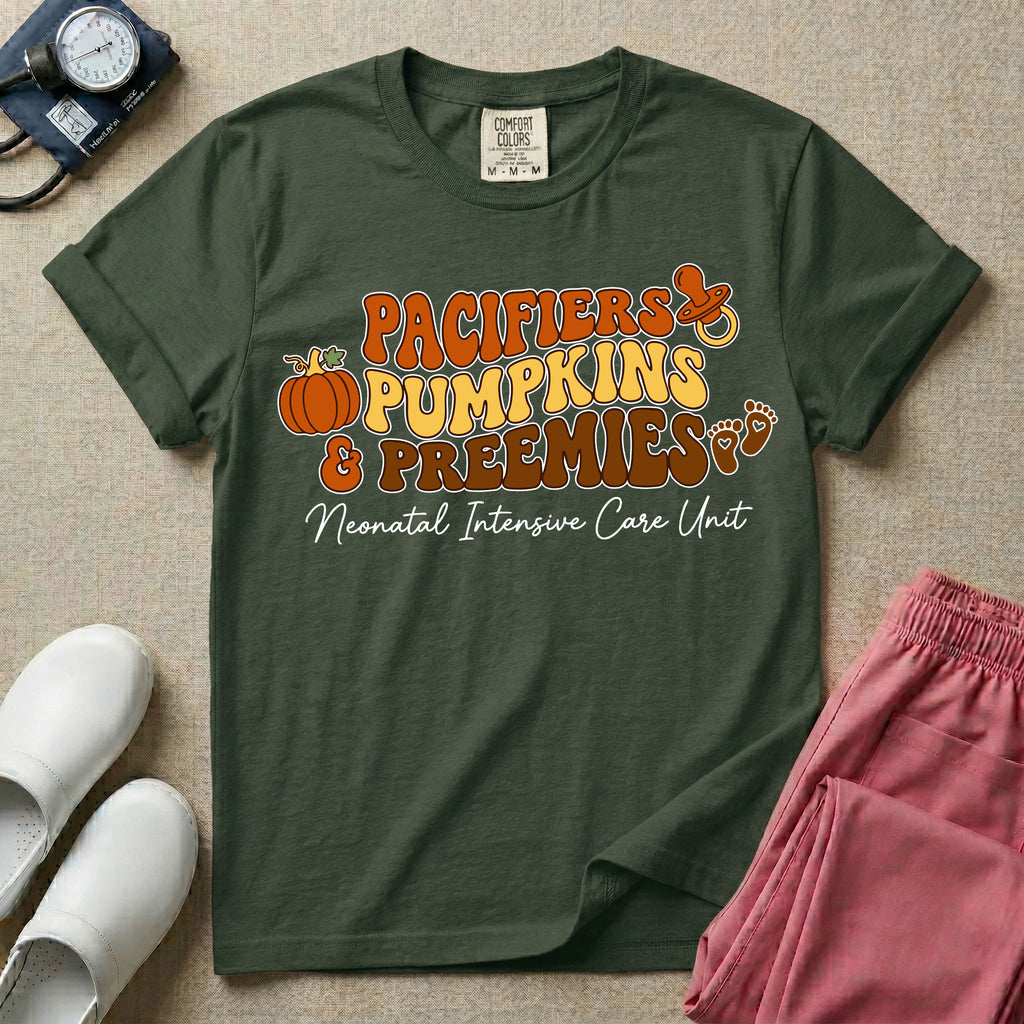 A t-shirt featuring the stacked text PACIFIERS PUMPKINS & PREEMIES in wavy orange, yellow, and brown retro lettering decorated with a pumpkin, pacifier, and baby footprints, with Neonatal Intensive Care Unit written in cursive below.