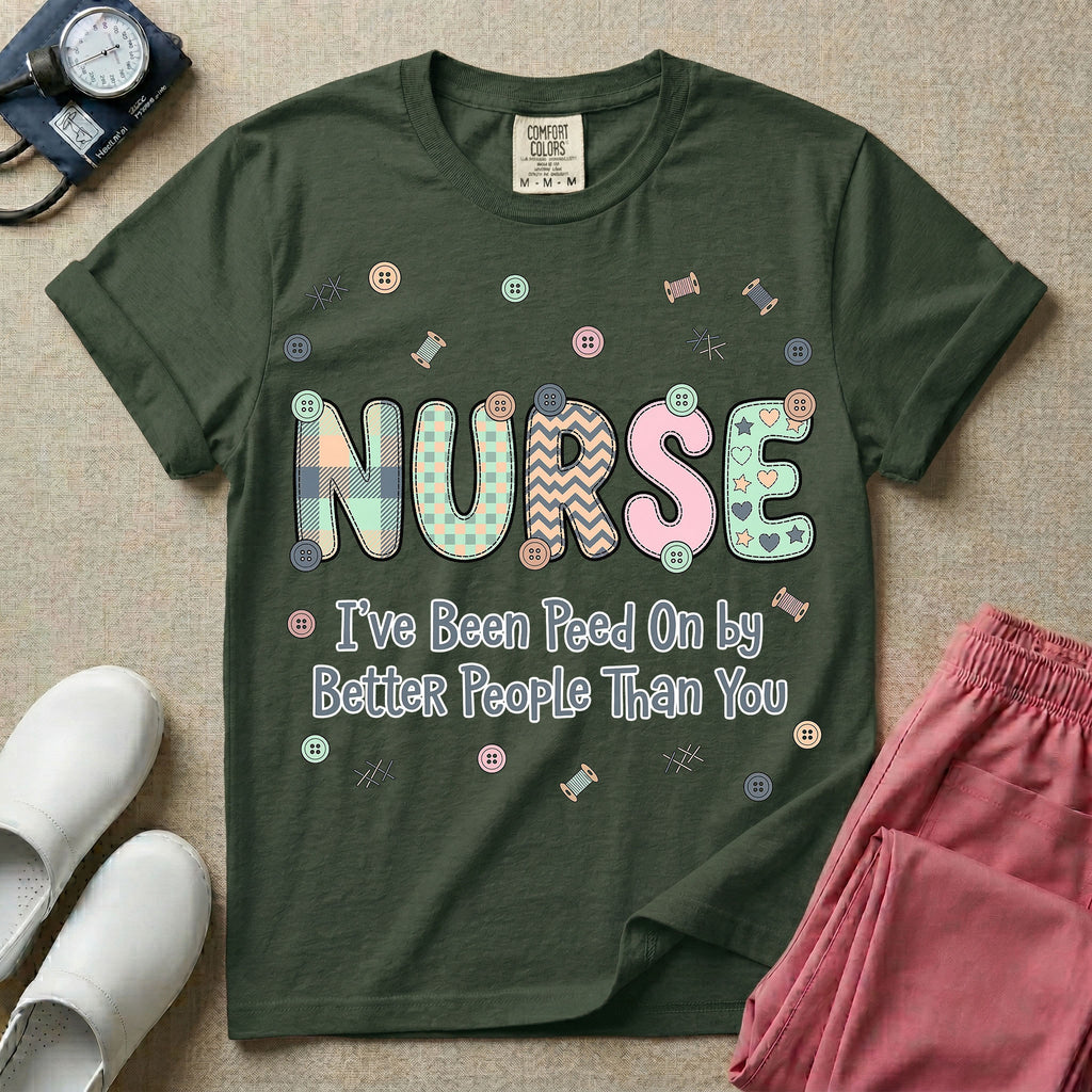 A humorous t-shirt for nurses featuring the word "NURSE" in colorful boho patterned letters above the funny phrase "I've Been Peed On by Better People Than You", surrounded by small abstract floral shapes.