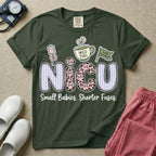 A funny t-shirt for NICU nurses featuring the large text "NICU" patterned with purple stripes and pink leopard print containing grumpy cat faces, accompanied by graphics of an IV bag with a pink bow, a steaming coffee cup reading "NICU FUEL", a green flag saying "Code Grumpy", and the bottom text "Small Babies. Shorter Fuses."