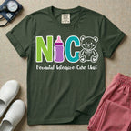 A t-shirt featuring the acronym NICU creatively spelled out using a green letter N, a purple baby bottle, a teal letter C, and a white outlined teddy bear, with the words Neonatal Intensive Care Unit written in cursive script below.
