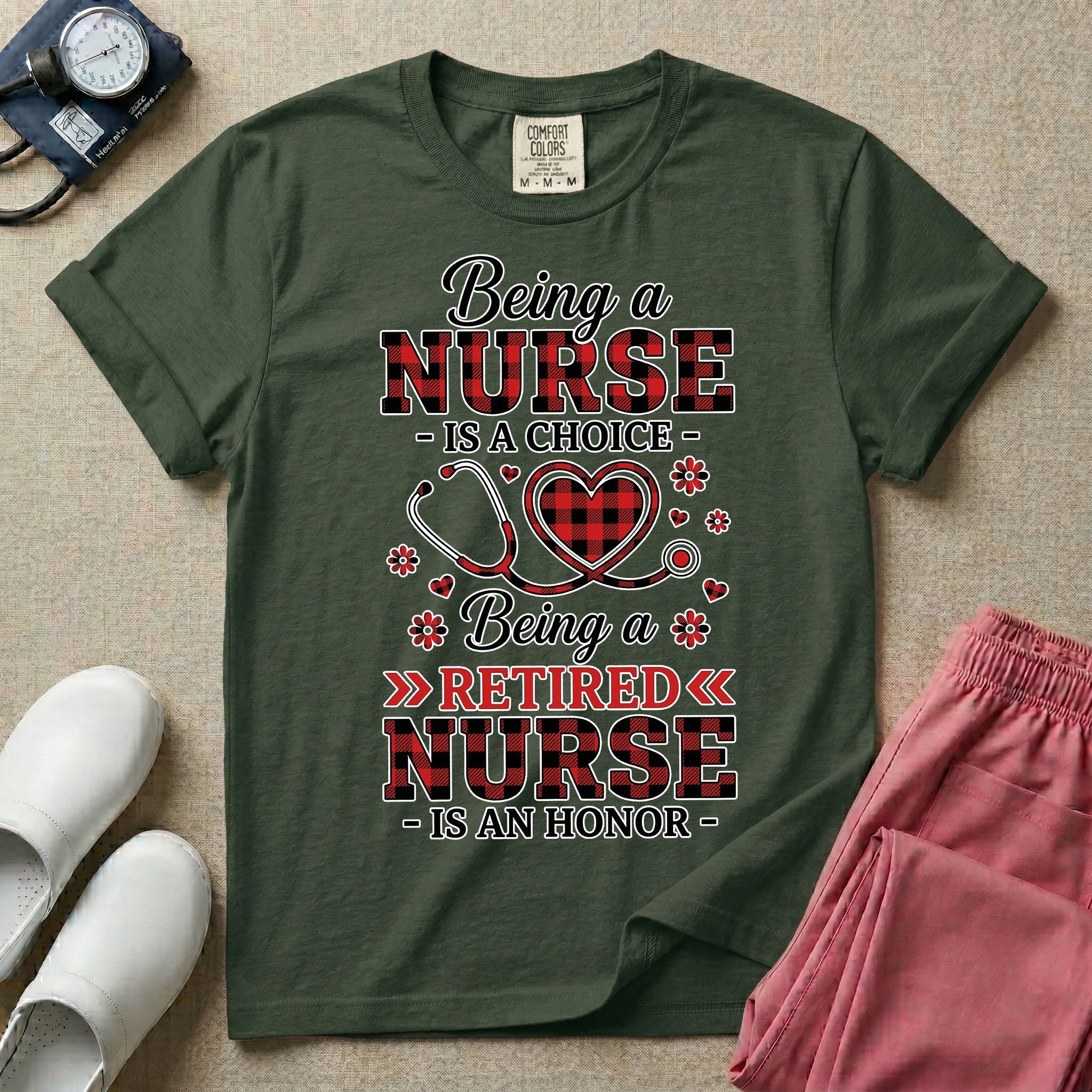 A t-shirt featuring the text Being a NURSE IS A CHOICE Being a RETIRED NURSE IS AN HONOR surrounding a central graphic of a red and black buffalo plaid heart intertwined with a stethoscope.