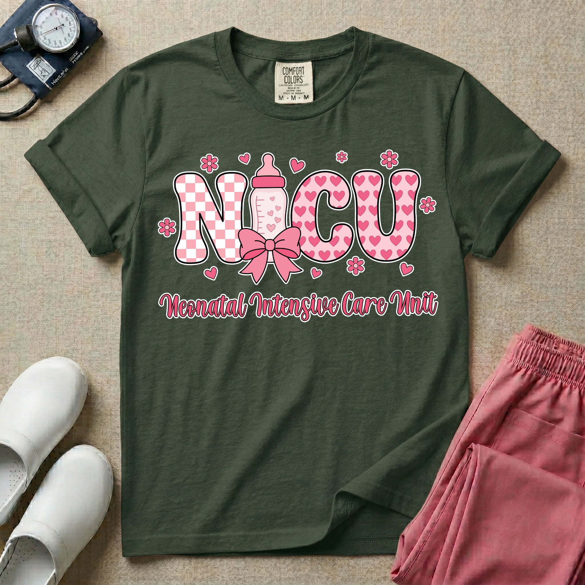 Retro coquette style t-shirt graphic featuring decorative pink 'NICU' text with checkerboard and heart patterns, incorporating a baby bottle with a bow and hearts, and the cursive text 'Neonatal Intensive Care Unit' below.