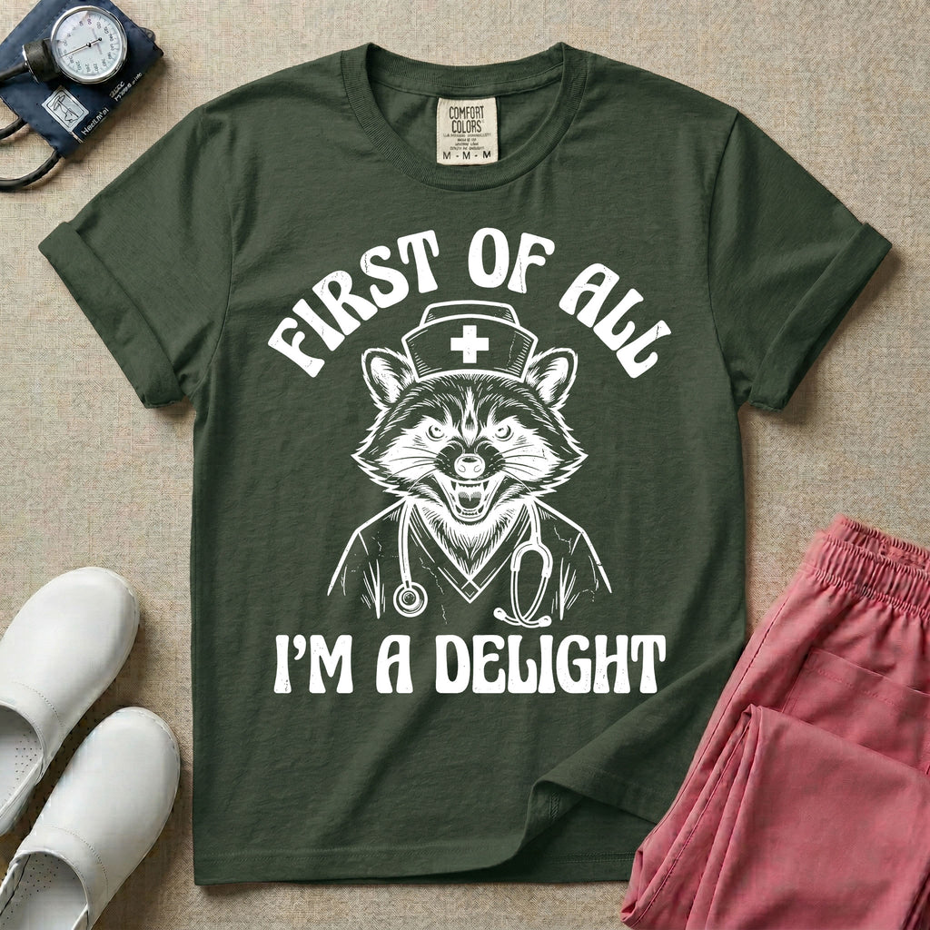 A humorous graphic of a raccoon dressed in a nursing cap and scrub jacket with a stethoscope, with the text "FIRST OF ALL I'M A DELIGHT", in moss color.