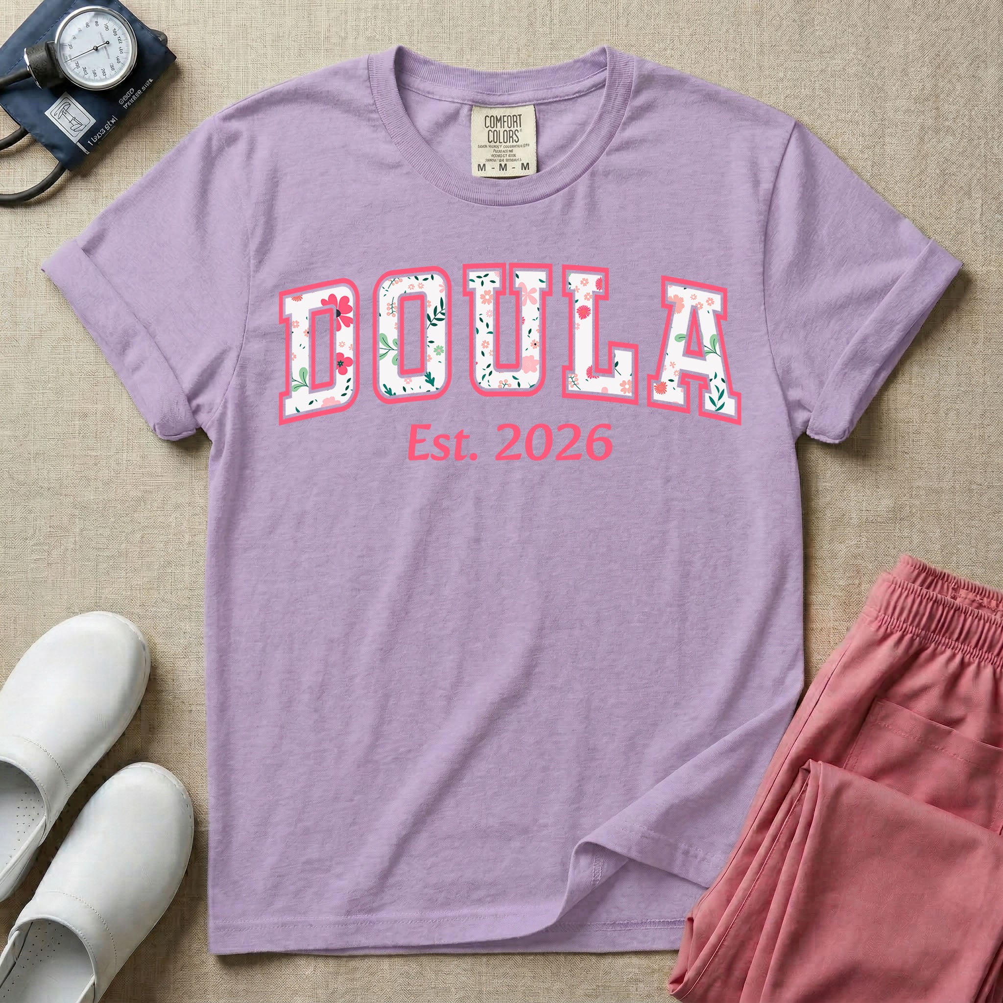 A personalized Doula graphic featuring the word DOULA in large, arched varsity-style letters filled with a delicate pink and green floral pattern, positioned above customizable text that reads Est. 2026.