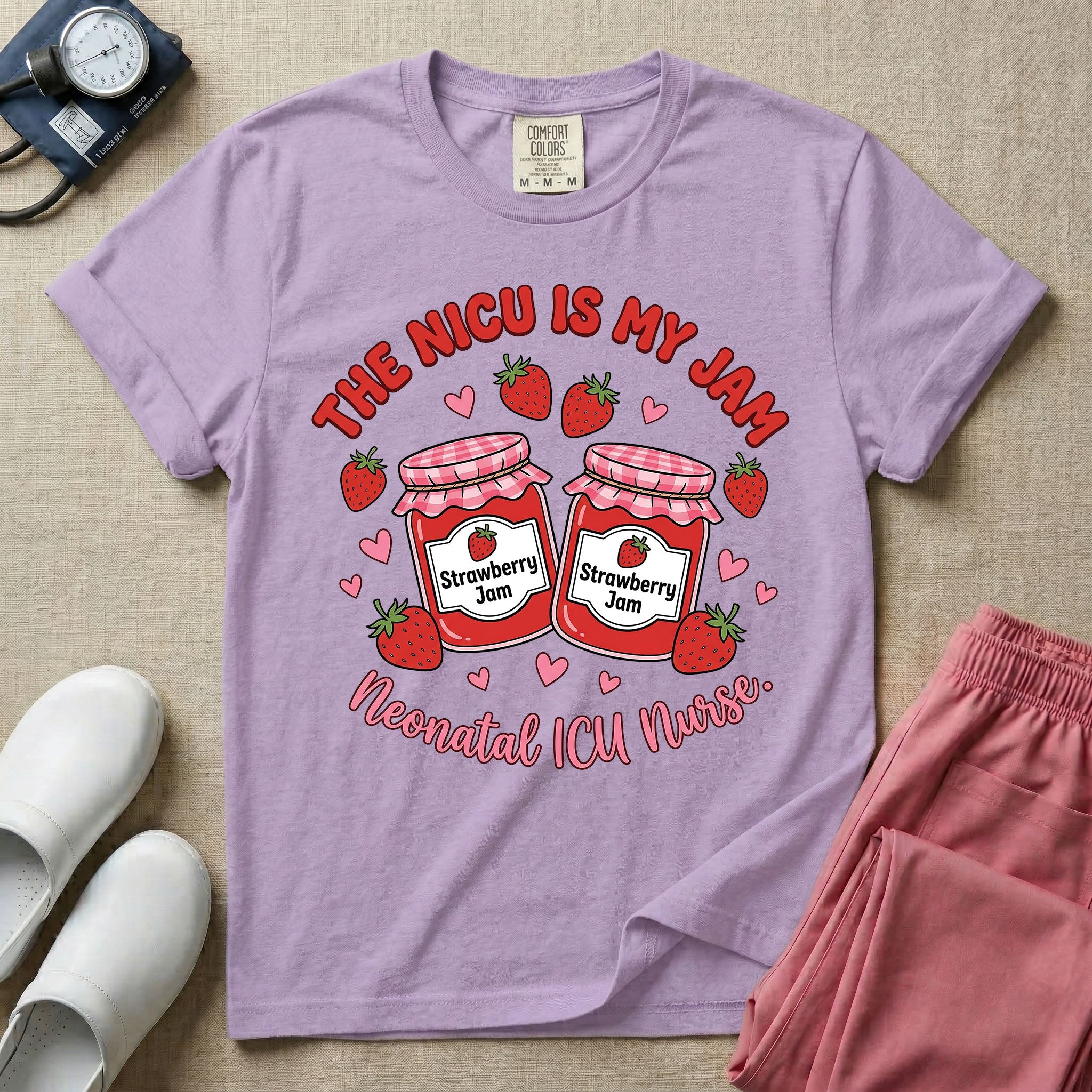 A t-shirt featuring two jars of strawberry jam surrounded by small hearts and strawberries with the text THE NICU IS MY JAM arched above and Neonatal ICU Nurse written in a retro script below.