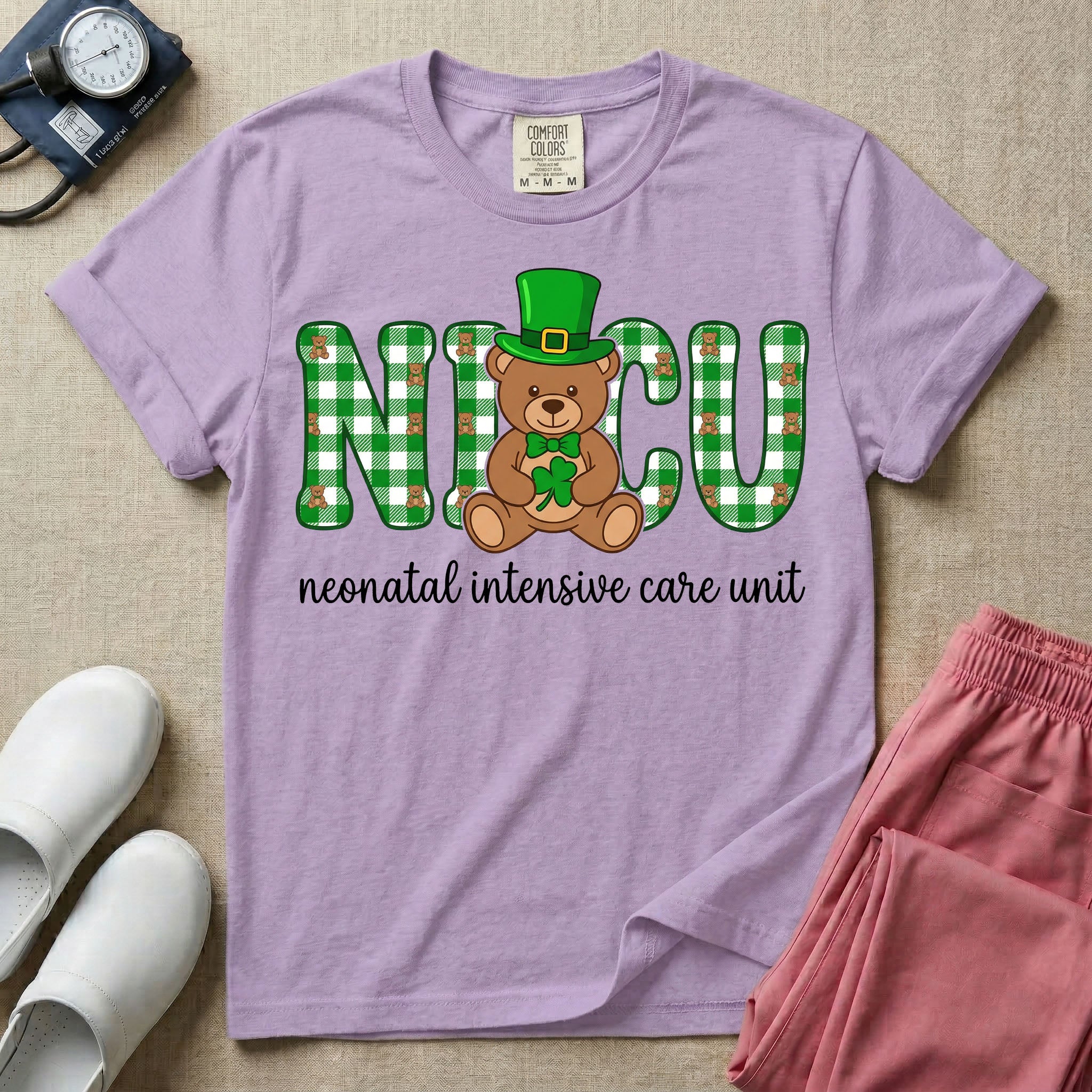 A graphic for a Neonatal Intensive Care Unit featuring the word 'NICU' in green and white plaid patterned letters, with a cute brown teddy bear wearing a leprechaun hat and holding a shamrock sitting in the middle, and the cursive text 'neonatal intensive care unit' underneath.
