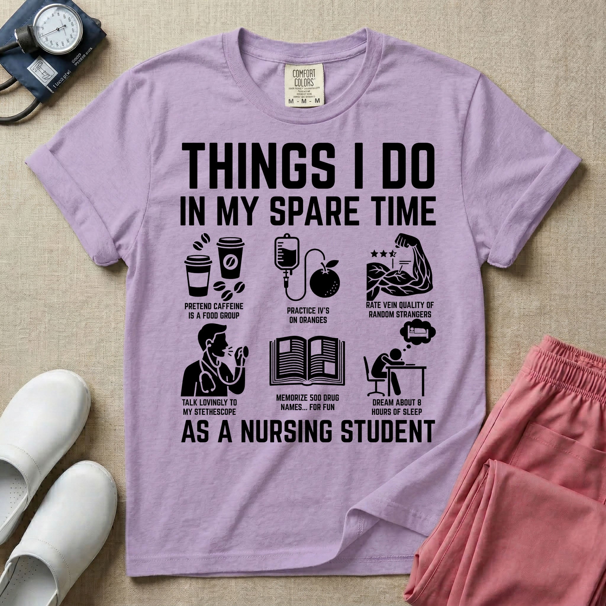 A t-shirt featuring the text THINGS I DO IN MY SPARE TIME AS A NURSING STUDENT surrounded by humorous line-art icons depicting studying, drinking coffee, and lacking sleep.