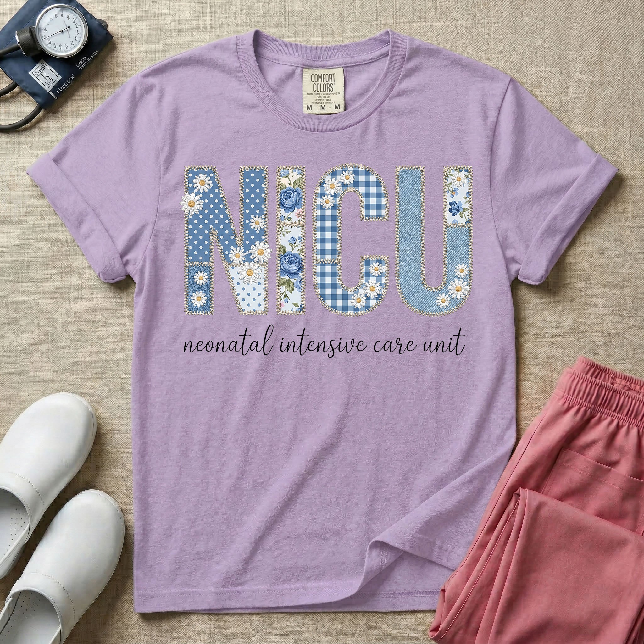 Neonatal Intensive Care Unit NICU nursing t-shirt featuring a faux-embroidery graphic of the letters NICU filled with blue floral and checkered patterns, positioned above the cursive text "neonatal intensive care unit".