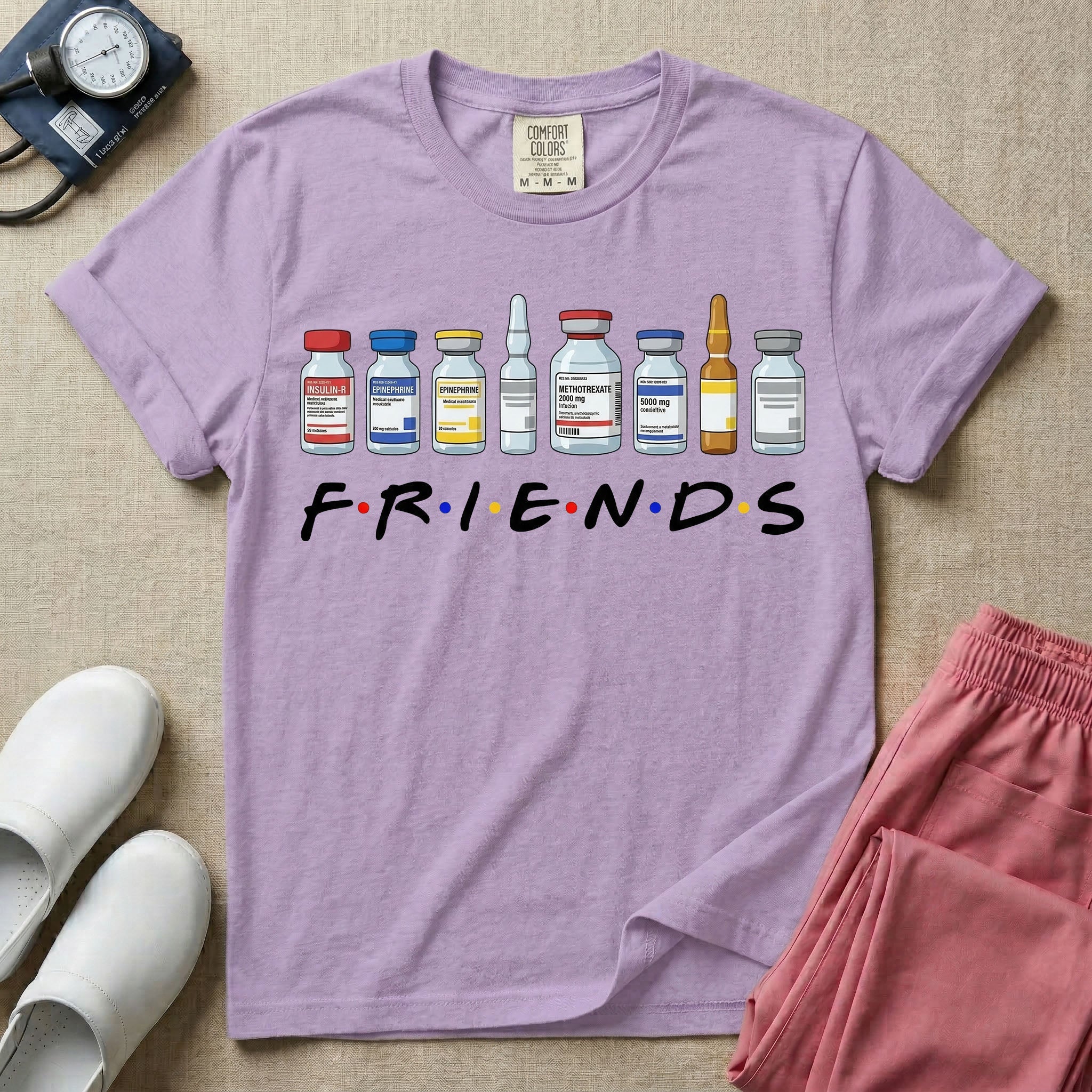 A humorous retro-style t-shirt for nurses featuring a row of seven different medical vials and medicine ampules lined up above the word "FRIENDS", which is styled with colored dots between the letters to resemble the classic television show logo.