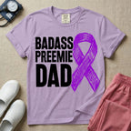 A graphic for the Neonatal Intensive Care Unit featuring the stacked, bold white text 'BADASS PREEMIE DAD' next to a large, textured purple awareness ribbon.
