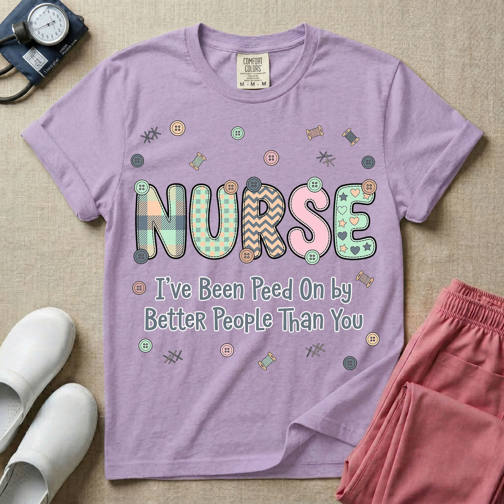A humorous t-shirt for nurses featuring the word "NURSE" in colorful boho patterned letters above the funny phrase "I've Been Peed On by Better People Than You", surrounded by small abstract floral shapes.