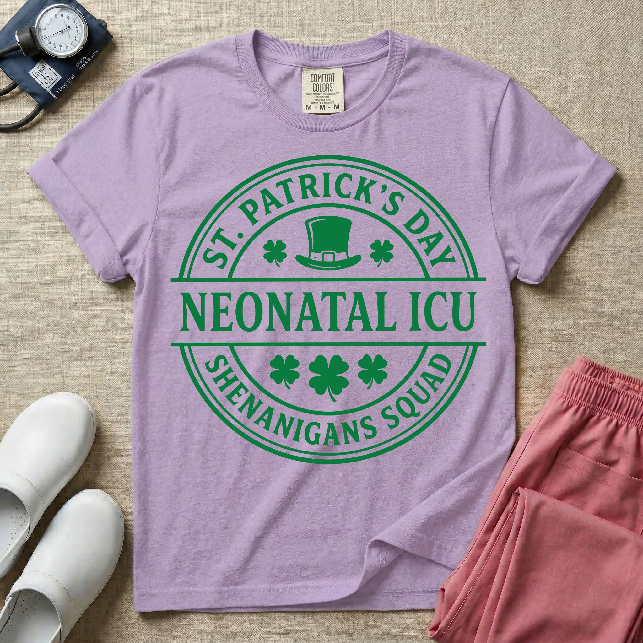 A circular green graphic featuring a leprechaun hat, shamrocks, and the text ST. PATRICK'S DAY SHENANIGANS SQUAD surrounding a center banner that reads NEONATAL ICU.