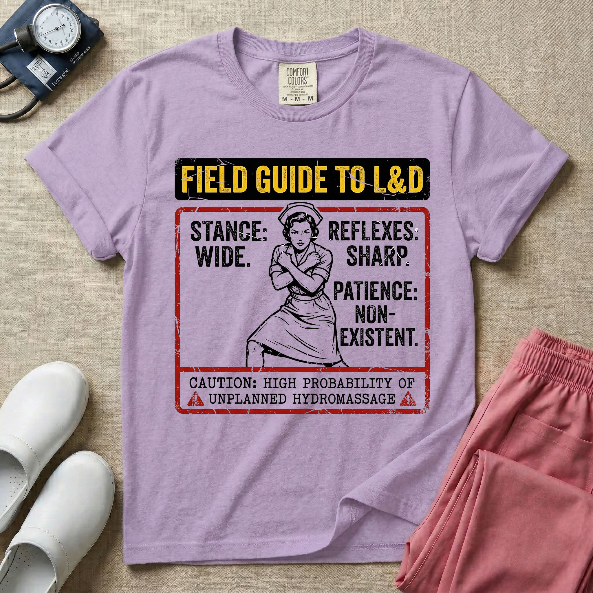A humorous and retro graphic tee for labor and delivery nurses featuring a vintage nurse illustration alongside the text "FIELD GUIDE TO L&D", "STANCE: WIDE", "REFLEXES: SHARP", "PATIENCE: NON-EXISTENT", and "CAUTION: HIGH PROBABILITY OF UNPLANNED HYDROMASSAGE".