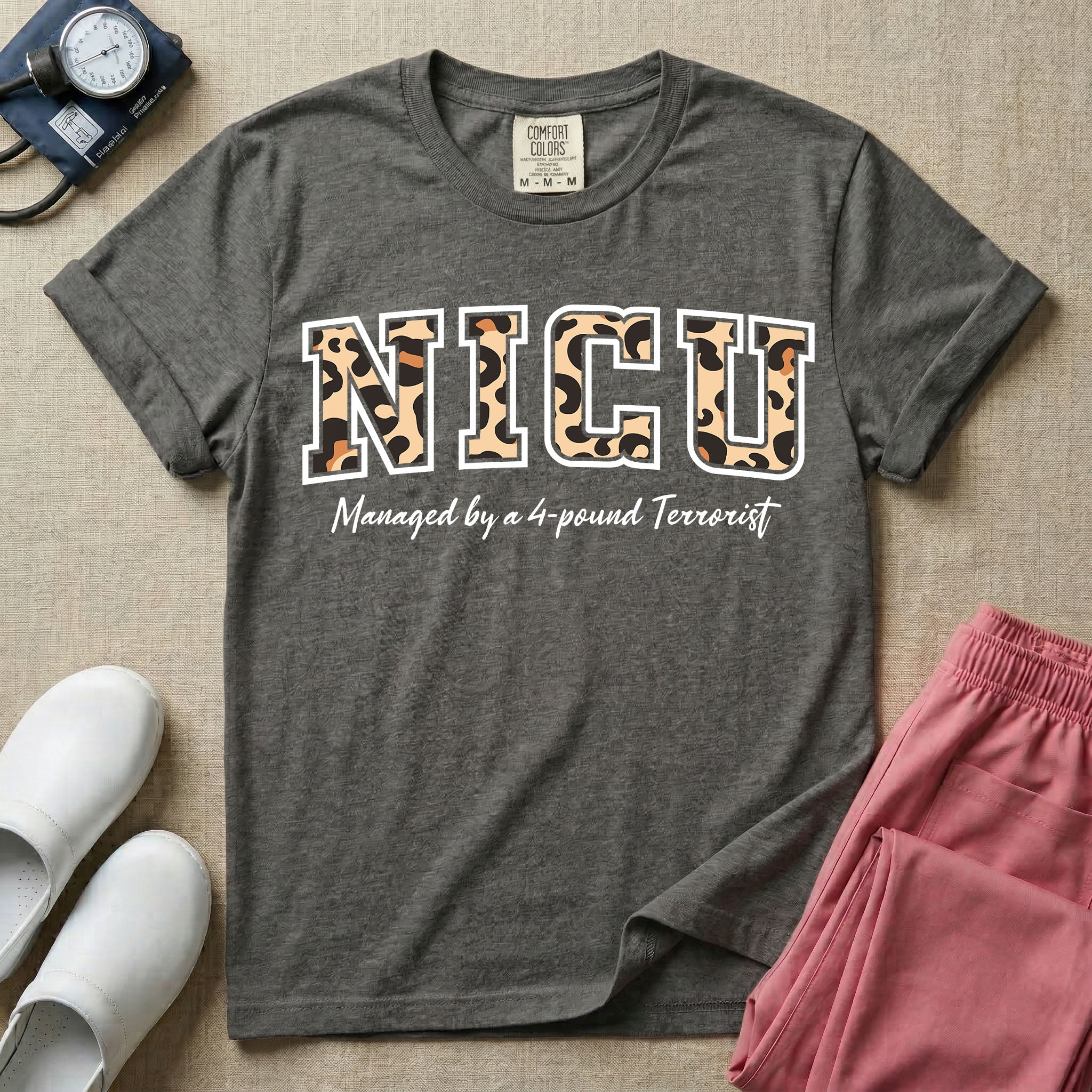 Neonatal Intensive Care Unit NICU nurse t-shirt with leopard print block letters and funny managed by a 4-pound terrorist graphic in pepper color.