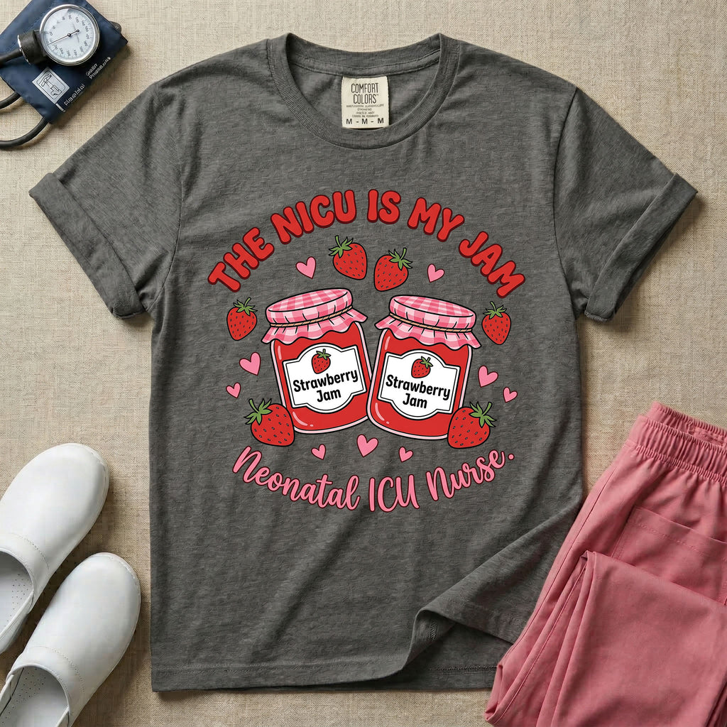 A t-shirt featuring two jars of strawberry jam surrounded by small hearts and strawberries with the text THE NICU IS MY JAM arched above and Neonatal ICU Nurse written in a retro script below.