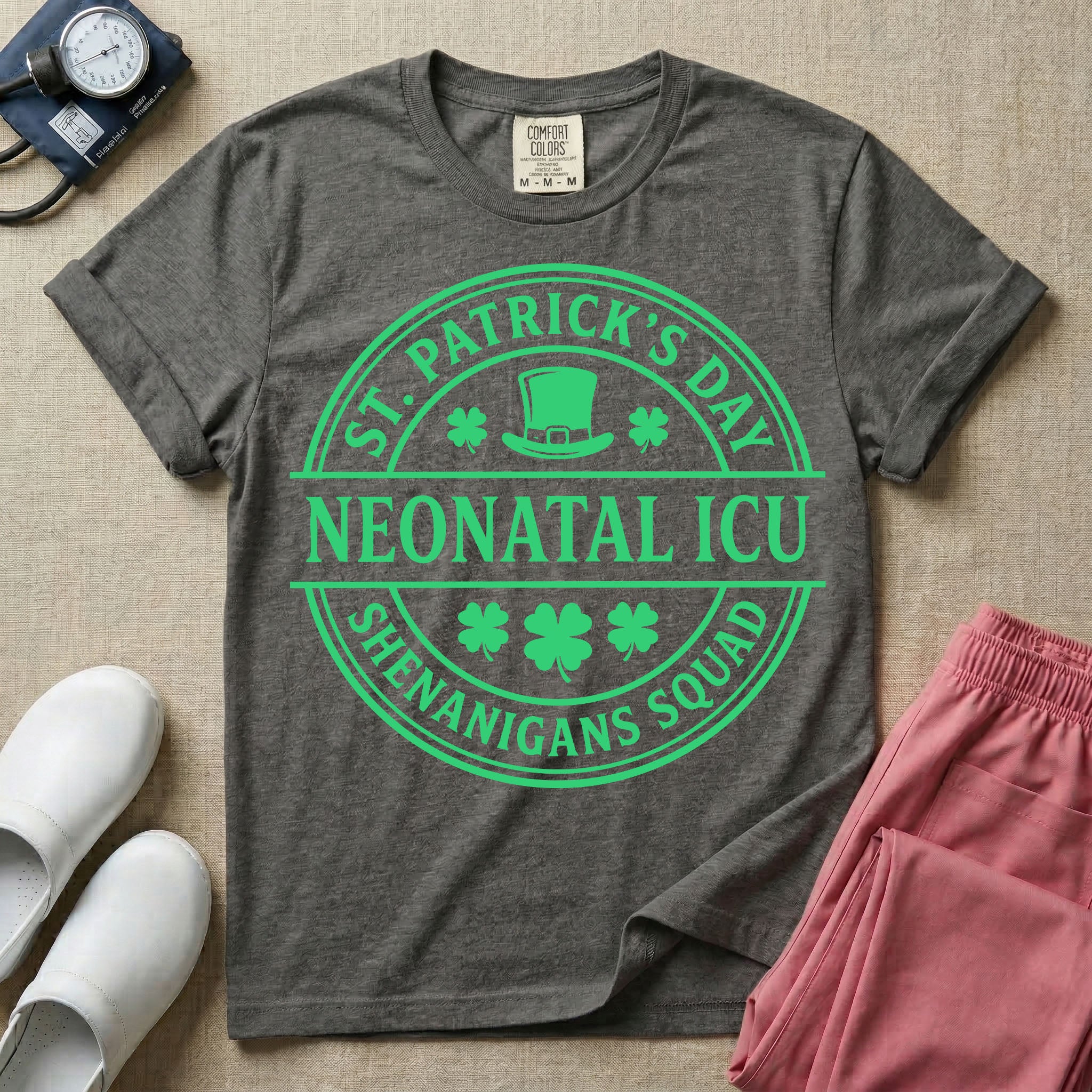 A circular green graphic featuring a leprechaun hat, shamrocks, and the text ST. PATRICK'S DAY SHENANIGANS SQUAD surrounding a center banner that reads NEONATAL ICU.