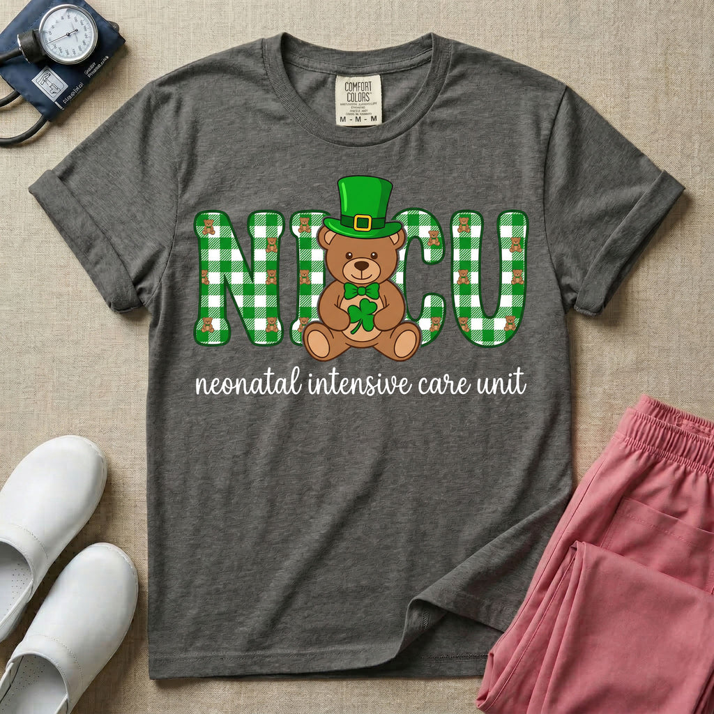 A graphic for a Neonatal Intensive Care Unit featuring the word 'NICU' in green and white plaid patterned letters, with a cute brown teddy bear wearing a leprechaun hat and holding a shamrock sitting in the middle, and the cursive text 'neonatal intensive care unit' underneath.