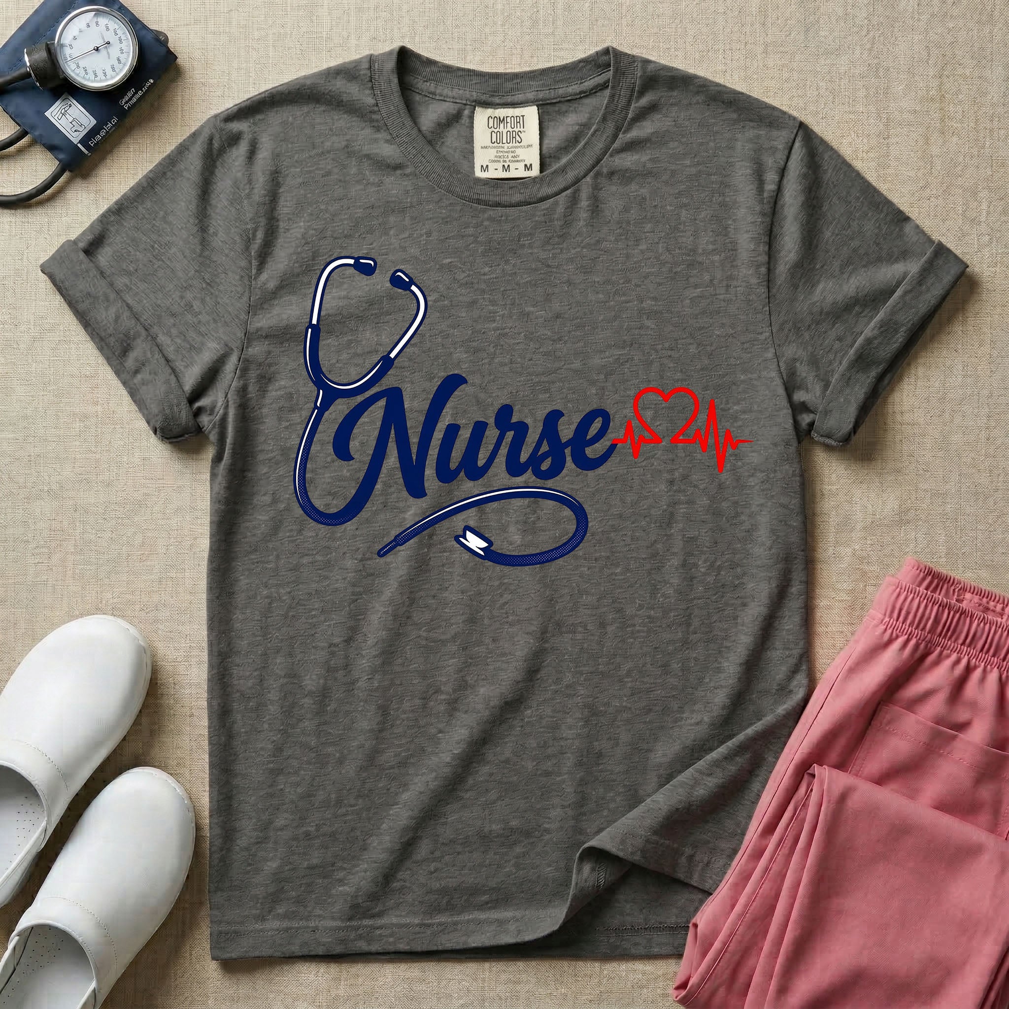 General nursing t-shirt with a minimalist cursive Nurse text integrated with a navy blue stethoscope and a red heartbeat graphic.