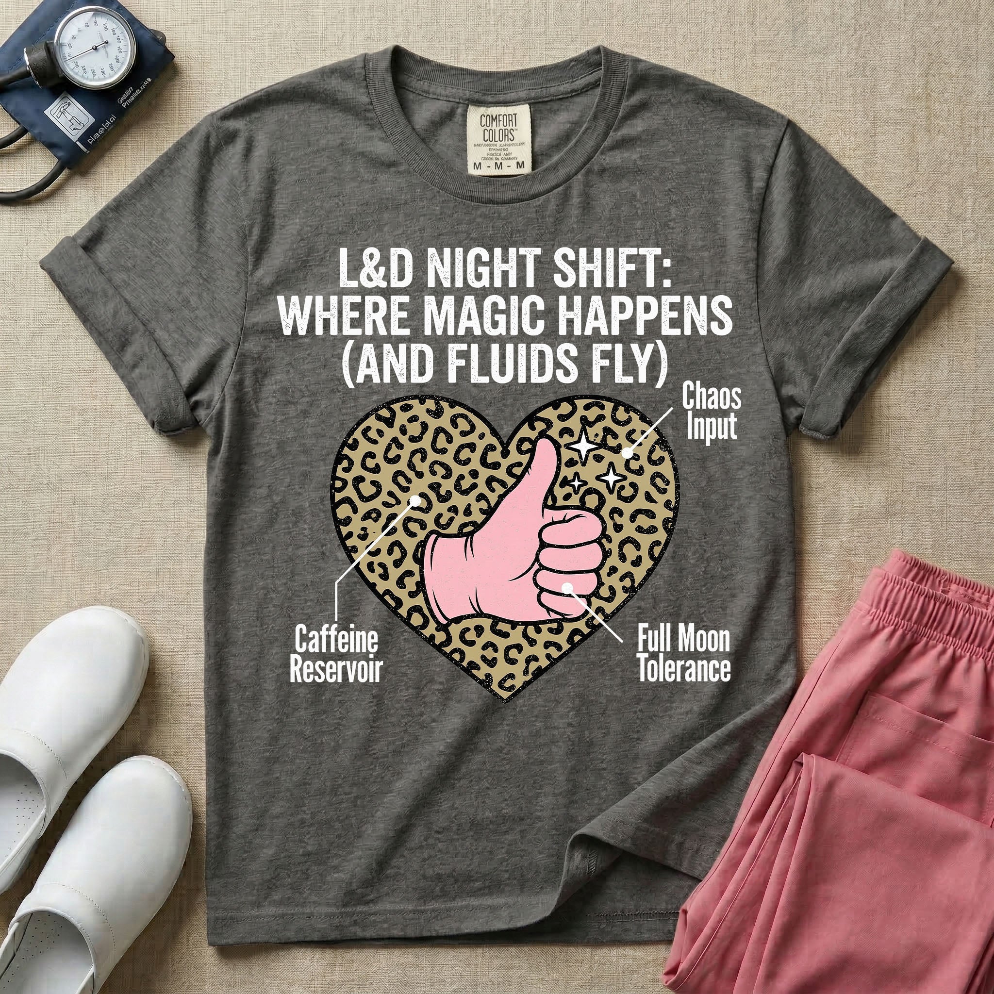 Labor and Delivery L&D nursing t-shirt featuring a leopard print heart diagram with a gloved thumbs-up and the text "L&D NIGHT SHIFT: WHERE MAGIC HAPPENS (AND FLUIDS FLY)"