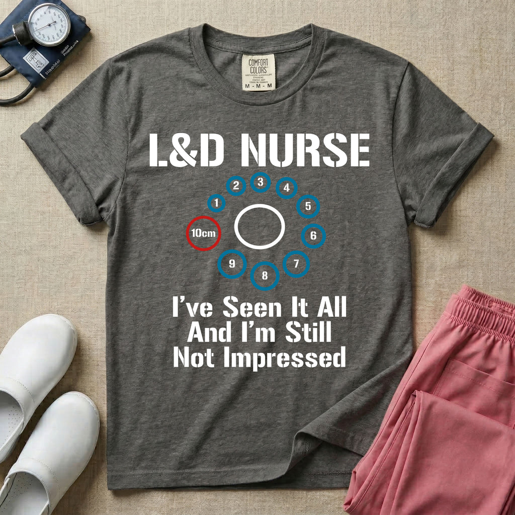A humorous Labor and Delivery nurse t-shirt featuring a cervical dilation chart graphic highlighting 10cm, with the text "L&D NURSE" at the top and "I've Seen It All And I'm Still Not Impressed" at the bottom.