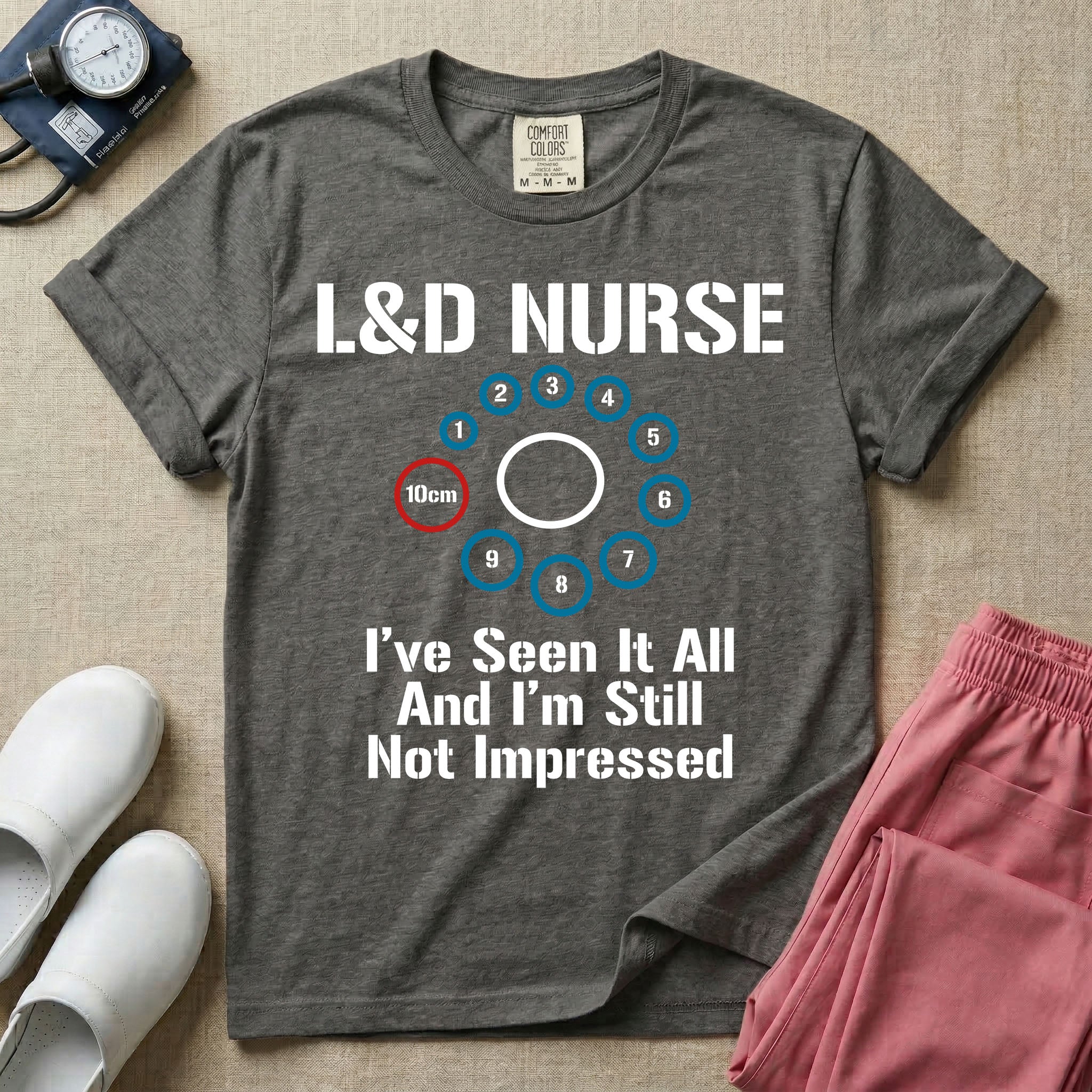 A humorous Labor and Delivery nurse t-shirt featuring a cervical dilation chart graphic highlighting 10cm, with the text "L&D NURSE" at the top and "I've Seen It All And I'm Still Not Impressed" at the bottom.