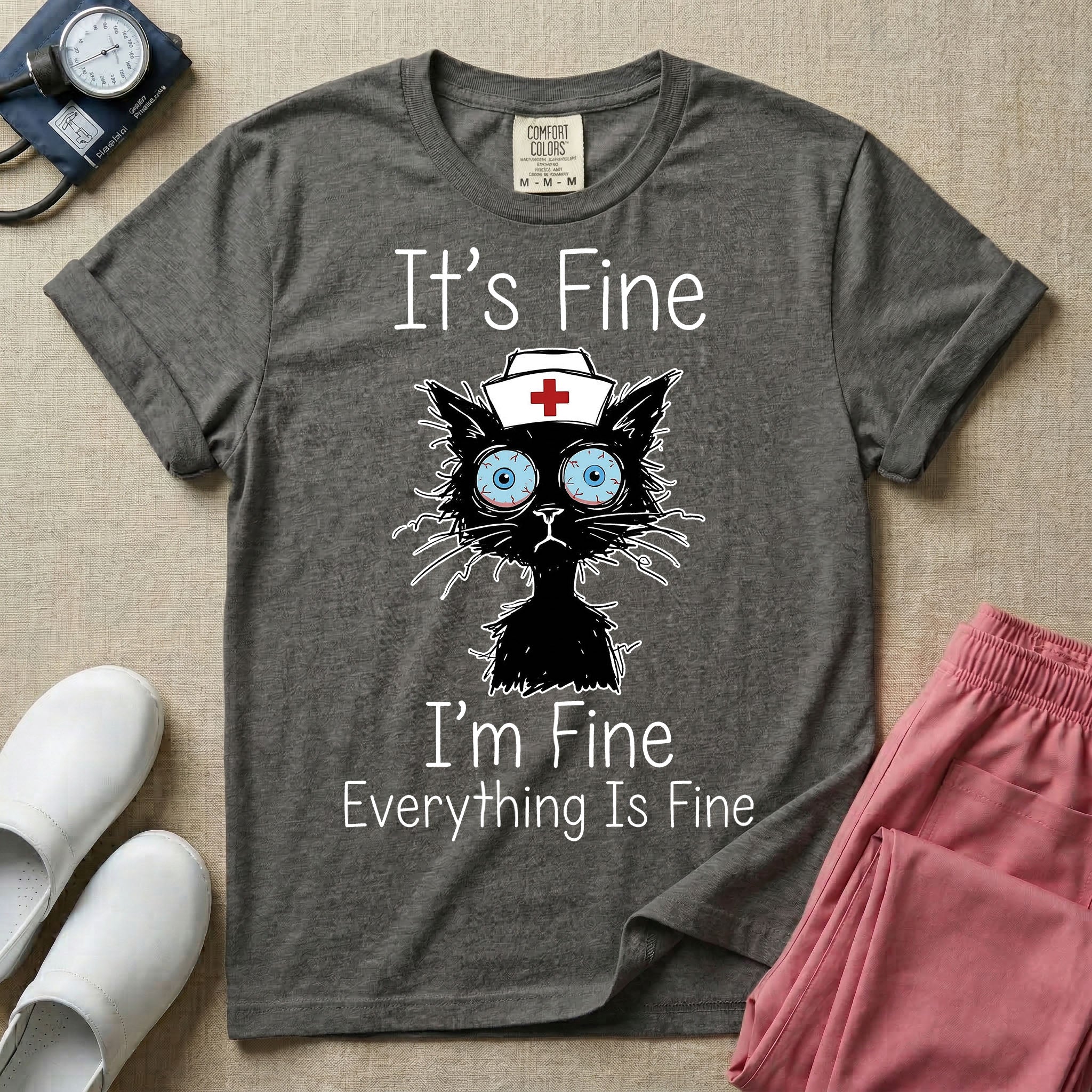 General nursing t-shirt featuring a humorous graphic of a frazzled black cat wearing a medical cross nurse cap alongside the text "It's Fine I'm Fine Everything Is Fine".